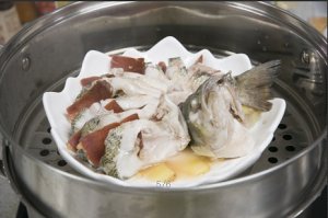 將鱸魚成花狀擺好，將火腿切片放入各縫隙中，放入鍋中隔水蒸12分鐘拿出，撒上蔥花即可。