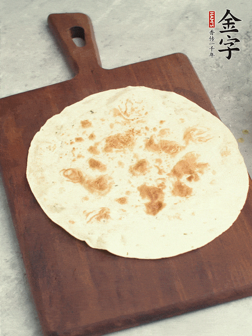 食材依次鋪在卷餅皮上，卷起來。