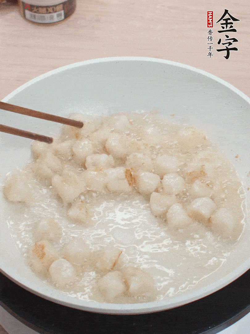 油溫4成熱，鮮貝蘸干淀粉下鍋煎，一面微黃后翻面。