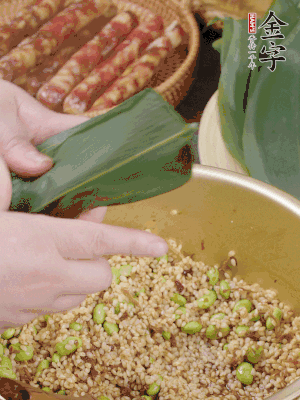 粽葉往下折，完全蓋住，兩側(cè)捏緊。