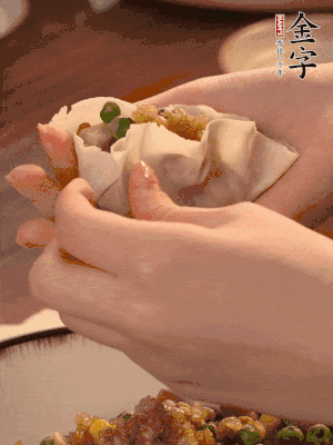 取一大勺餡料放進餃子皮里，用大拇指按住頂部餡料，再用虎口掐出形狀。