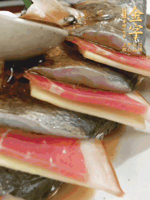 魚肚中塞蔥結(jié)、火腿片，魚身上碼放姜片、火腿片，倒入混合的料汁。