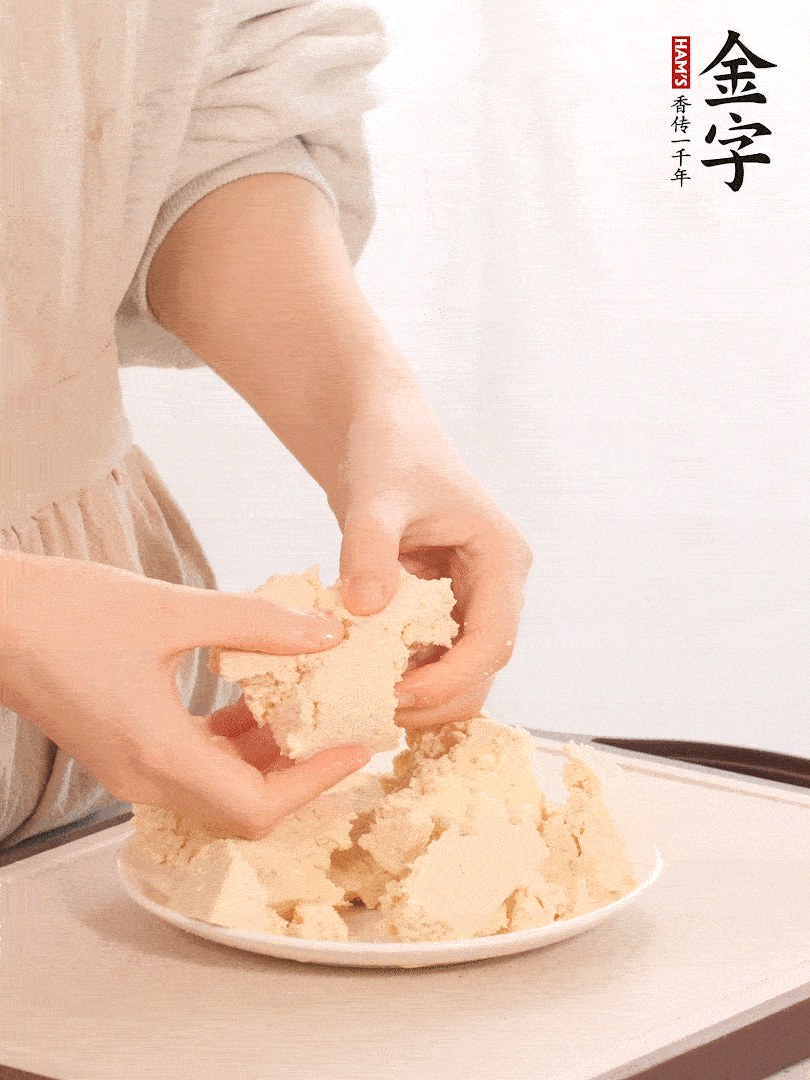 老豆腐用手掰成塊。