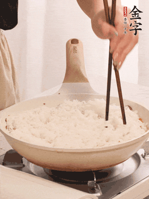 把瀝干水分的米飯均勻鋪在上面，筷子戳幾個洞，以便透氣，轉(zhuǎn)小火蓋上蓋子燜至水分收干，大概10分鐘。